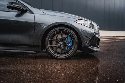 Dark gray BMW M2 on Masata lowering springs with black wheels and blue calipers.